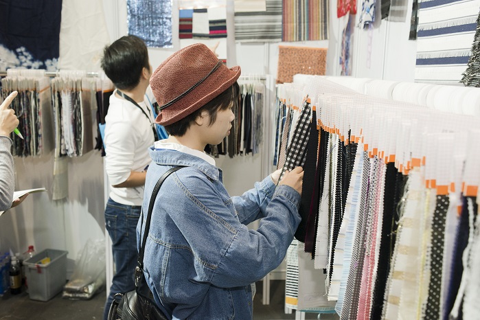 Buyer with products. © Messe Frankfurt / Intertextile Shanghai Apparel Fabrics
