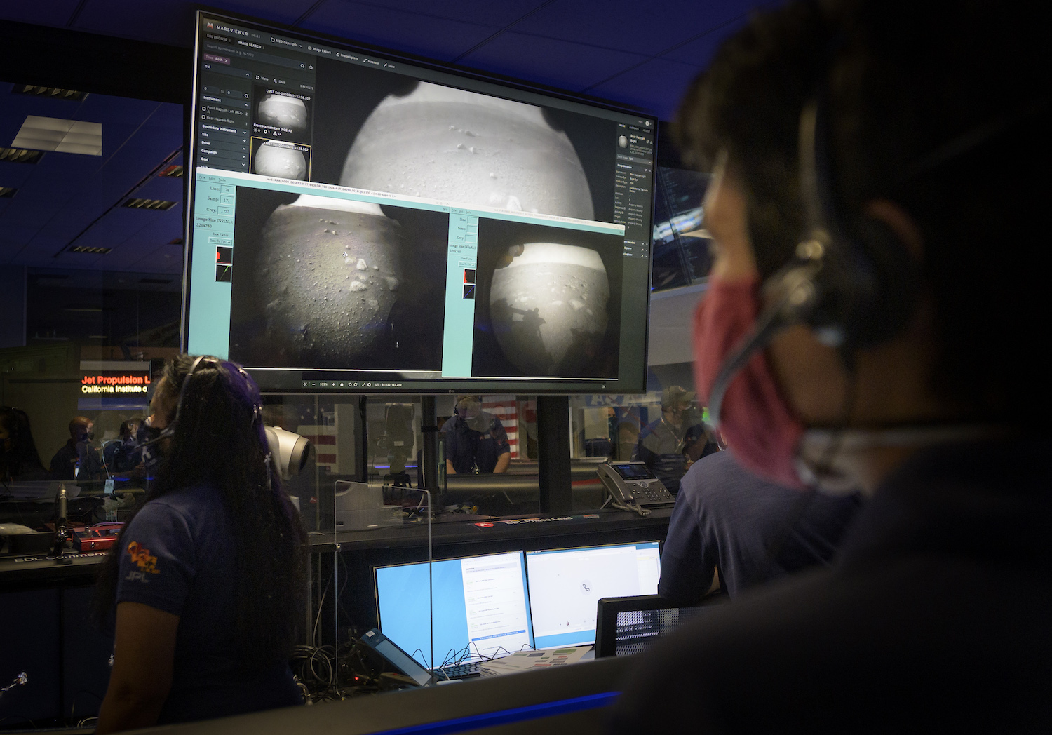 Members of NASA’s Perseverance Mars rover team watch in mission control as the first images arrive moments after the spacecraft successfully touched down on Mars, Thursday, Feb. 18, 2021, at NASA’s Jet Propulsion Laboratory in Pasadena, California. © NASA/Bill Ingalls.