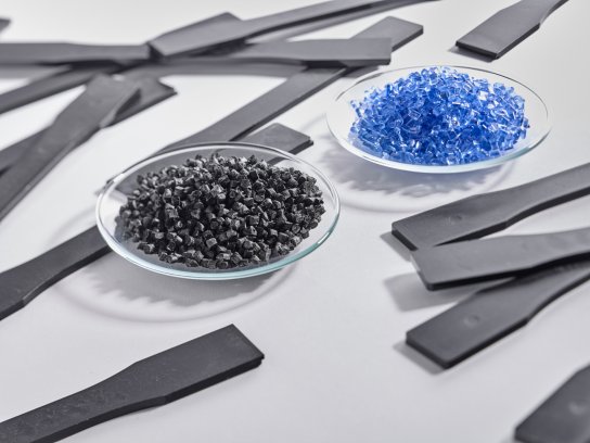 The recycled polycarbonate composites are blended with new polycarbonates (the light blue granules) to form new plastic products (the black granules). © carboNXT