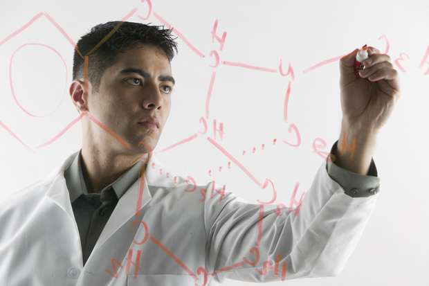 Researcher writing forms on a table translucent. ©Corbis - Solvay photolibrary