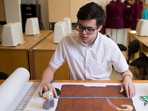 Senior fashion design student Luis Quijano measures and cuts a material he grew himself using a mixture of ordinary household ingredients. © Jessie Rogers