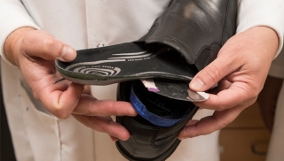 Erik Thostenson, an associate professor in the Departments of Mechanical Engineering and Materials Science and Engineering, demonstrates how a sensor could be placed inside a shoe to measure foot pressure. © Photo by Kathy F. Atkinson. 